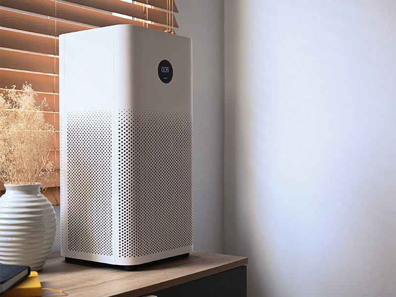 Indoor air purifier unit sitting on top of a dresser.